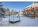 Snowy backyard with playground and deck; home visible in background at 7339 Shoreham Pl, Castle Pines, CO 80108