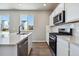 Modern kitchen with stainless steel appliances and an island at 9998 Racine St, Commerce City, CO 80022