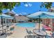 Community pool area with lounge chairs, tables, and umbrellas at 1801 S Dunkirk St # 303, Aurora, CO 80017