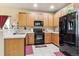 Well-equipped kitchen boasting wood cabinets, black appliances, and generous counter space at 14389 E 101St Pl, Commerce City, CO 80022