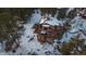 Aerial view of a charming mountain home with snow-covered landscape and deck at 8838 Hillview Rd, Morrison, CO 80465