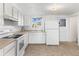 Small kitchen with white cabinets and appliances at 4170 Chase St, Denver, CO 80212