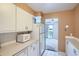 White kitchen cabinets and appliances, view into living room at 460 S Marion Pkwy # 702, Denver, CO 80209