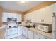 Efficient kitchen with white cabinets and appliances at 460 S Marion Pkwy # 702, Denver, CO 80209