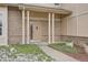 Inviting house entrance with brick facade, landscaping, and a light beige door at 9357 Lark Sparrow Dr, Highlands Ranch, CO 80126