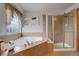 Bathroom features a large corner soaking tub and a separate shower at 15453 E 109Th Ave, Commerce City, CO 80022