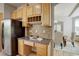 Kitchen features light wood cabinets, granite countertops, and a built-in desk at 15453 E 109Th Ave, Commerce City, CO 80022
