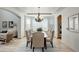 Formal dining room with a chandelier and beige upholstered chairs at 15453 E 109Th Ave, Commerce City, CO 80022
