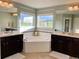 Spa-like bathroom with double vanities, a large soaking tub, and a window at 2393 Fairway Wood Cir, Castle Rock, CO 80109