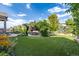 Landscaped backyard with pergola, seating area, and artificial turf at 711 Hiddenbrook Ct, Highlands Ranch, CO 80126