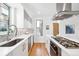 Modern white kitchen with stainless steel appliances and herringbone backsplash at 3334 Tejon St # 1, Denver, CO 80211