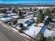 Aerial view showing a house with a large yard, a snow-covered lawn and mountain views in the background at 6101 S University Blvd, Centennial, CO 80121