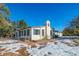 Charming ranch-style home with snow-covered landscaping, a spacious yard, and mountain views at 6101 S University Blvd, Centennial, CO 80121