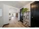 Hallway with light wood floors, a plant stand, and views into the living room and dining area at 6101 S University Blvd, Centennial, CO 80121