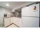 Small kitchen with white cabinets, microwave, and full-size refrigerator at 6101 S University Blvd, Centennial, CO 80121