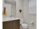 Clean and modern bathroom with a dark brown vanity and a white toilet at 30 S Oneida St, Denver, CO 80230