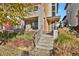 Modern home's front entrance with steps leading up to covered porch at 30 S Oneida St, Denver, CO 80230