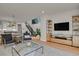 Open concept living room showcasing a stylish TV stand and a view into the kitchen at 30 S Oneida St, Denver, CO 80230