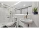 Modern bathroom with a pedestal sink, walk-in shower, and updated fixtures at 1454 Rosemary St, Denver, CO 80220