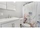 Clean bathroom with a white vanity, toilet, and floral shower curtain at 1454 Rosemary St, Denver, CO 80220