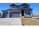 Two-story home with gray siding, stone accents, and a three-car garage at 39731 Congress Ln, Elizabeth, CO 80107