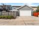 Gray house with attached two-car garage and fenced backyard at 5524 Uinta St, Denver, CO 80238