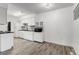 White kitchen with modern appliances and wood-look floors at 1830 Newland Ct # 106, Lakewood, CO 80214