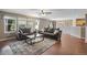 Open living room with hardwood floors, a cozy fireplace and view into kitchen at 1160 Cardinal Ave, Brighton, CO 80601