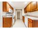 Efficient kitchen featuring wood cabinets, white appliances, and tile floor at 6061 W Utah Ln, Lakewood, CO 80232