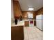 Galley kitchen with wood cabinets and white appliances at 650 S Clinton St # 5B, Denver, CO 80247
