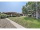 Spacious backyard with a grassy lawn, mature trees, and a gravel pathway at 6335 Martin Luther King Jr Blvd, Denver, CO 80207