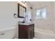 Updated bathroom with marble tile and modern vanity at 6335 Martin Luther King Jr Blvd, Denver, CO 80207