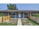 Ranch style home with gray siding and wooden fence at 6335 Martin Luther King Jr Blvd, Denver, CO 80207