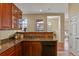 Kitchen with granite counters, wood cabinets, and a view into the dining area at 3950 E 127Th Ave, Thornton, CO 80241