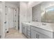 Modern bathroom with double vanity, large mirror, and walk-in shower at 9314 Quartz St, Arvada, CO 80007