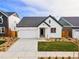 White farmhouse style home with a two-car garage and landscaping at 9314 Quartz St, Arvada, CO 80007