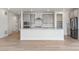 Open kitchen with gray cabinets, white island, and a brick backsplash at 9314 Quartz St, Arvada, CO 80007
