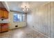 Dining area with wood-paneled walls, a chandelier, and patterned flooring at 1641 S Sheridan Blvd, Lakewood, CO 80232