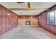 Living room with wood-paneled walls, brick fireplace and carpet at 11326 E Berry Dr, Englewood, CO 80111