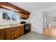 Kitchen with wood cabinets, black appliances, and vinyl flooring at 1450 S Yarrow St, Lakewood, CO 80232