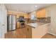 Simple kitchen with wood cabinets, stainless steel appliances, and a breakfast bar at 22281 E Navarro Pl, Aurora, CO 80018