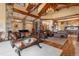 Spacious living room with high ceilings, exposed beams, and a stone fireplace at 456 Crystal Ridge Rd, Evergreen, CO 80439