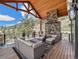 Covered deck with stone fireplace and mountain views at 456 Crystal Ridge Rd, Evergreen, CO 80439