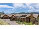 Mountain home with stone exterior and large driveway at 456 Crystal Ridge Rd, Evergreen, CO 80439