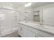 Bright bathroom with dual vanity sinks, a glass shower, and white cabinetry at 663 N Amory St, Watkins, CO 80137