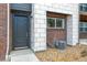 Front exterior of the home with a gray door, brick and stone facade, and a concrete pathway at 455 Interlocken Blvd # 102, Broomfield, CO 80021