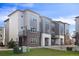 Modern three-story townhome with brick and gray siding at 455 Interlocken Blvd # 102, Broomfield, CO 80021