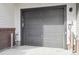 Exterior of two-car garage with a gray door, brick accents, and house number at 455 Interlocken Blvd # 102, Broomfield, CO 80021