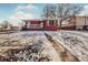 Brick ranch home with a covered porch and snowy lawn at 2200 W Moffat Pl, Denver, CO 80221