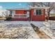 Brick ranch home with a covered porch and snowy lawn at 2200 W Moffat Pl, Denver, CO 80221